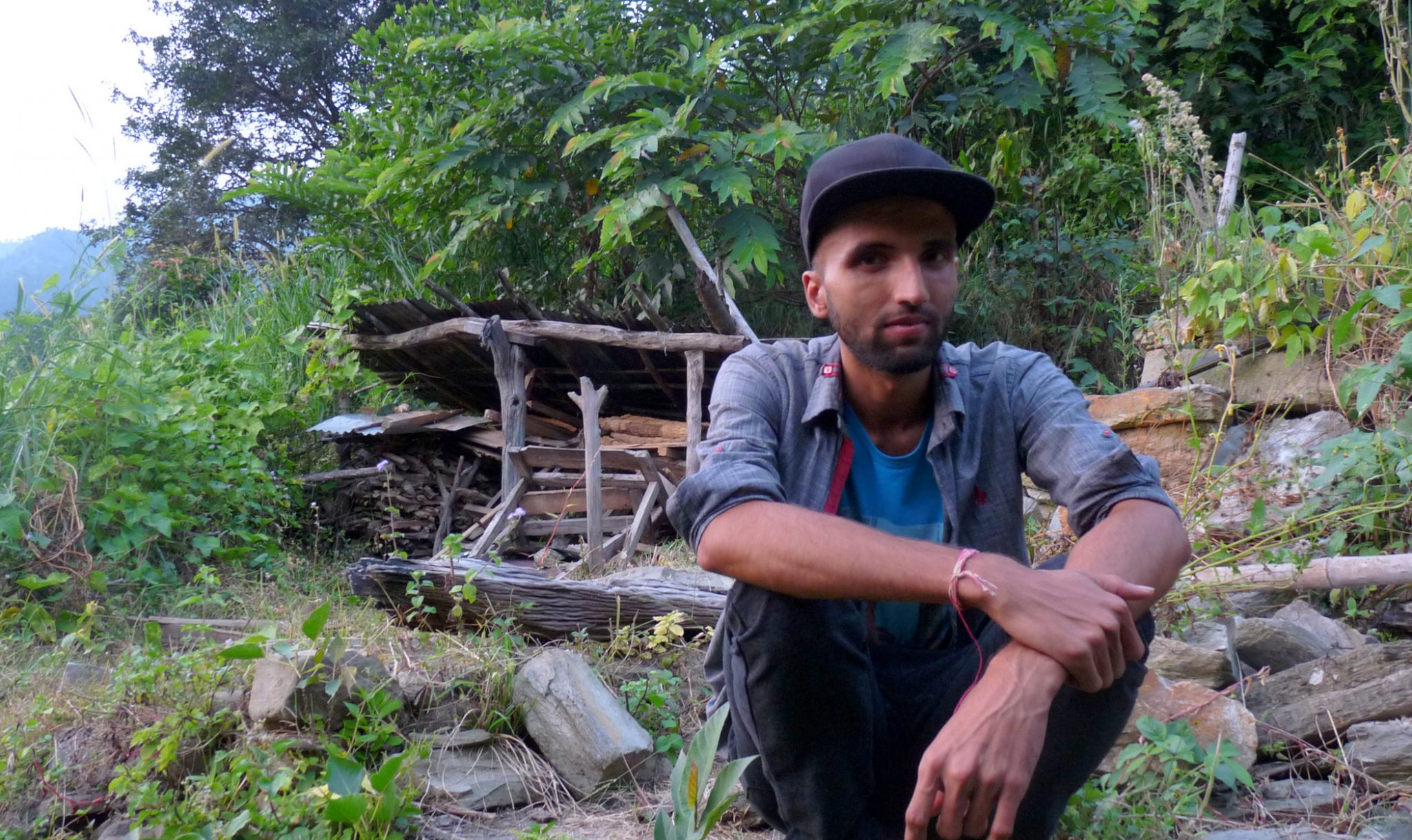 Ram Sharan Parajuli next to his old house.