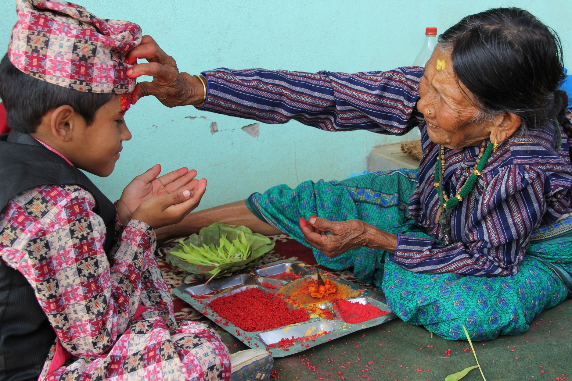 His mother, Bhagbati Thapa, as matriarch of the family, receives kinfolk from far and wide to bestow tika, a significant blessing of good fortune for the coming year. “This is an important tika for us,” added Krishna. “We have to hope for the future.” Their house may be irreparably damaged, but it was still put to good use by the thirty friends and relatives who congregated outside in its shade to eat, chat and play games. For this Dashain, as in previous years, the hills of Gorkha resound with drumming, singing and laughter well into the early hours. 