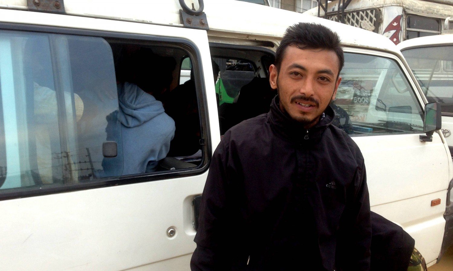 Rajul Mahnama waits by his minibus for fuel on Kathmandu's Ring Road. Like many others, he has been waiting days for a much-needed refill.